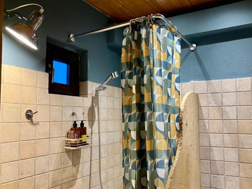 a shower with a colorful shower curtain in a bathroom at Melivista in Melívoia