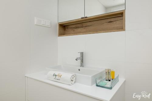 a bathroom sink with a roll of toilet paper on it at Prestige Pinea 713 - Easy - Rent Apartments in Pobierowo