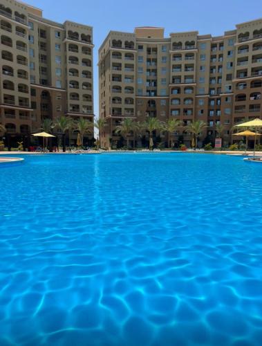 a large swimming pool in front of buildings at قريه اكوا فيو الساحل الشمالي العلمين in El Alamein