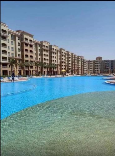 a large blue swimming pool in a resort at قريه اكوا فيو الساحل الشمالي العلمين in El Alamein