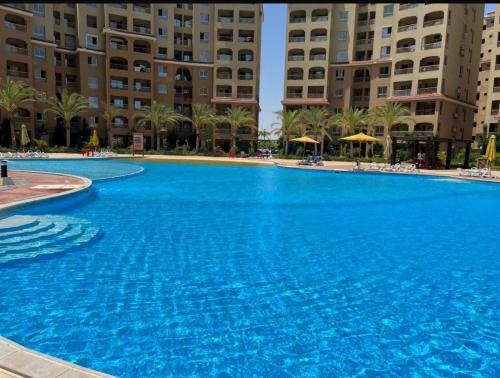 a large blue swimming pool in front of buildings at قريه اكوا فيو الساحل الشمالي العلمين in El Alamein