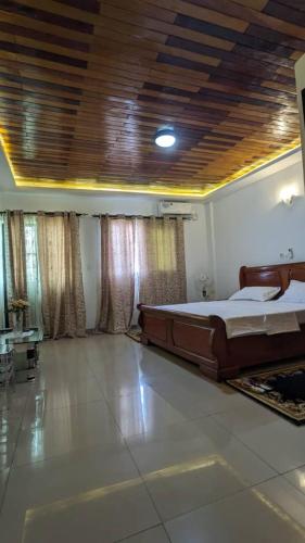 un dormitorio con una cama grande en una habitación en MB Suite Cogefar, en Douala