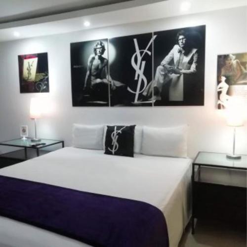 a bedroom with a bed with two tables and pictures on the wall at Mayafair All Inclusive in Cancún
