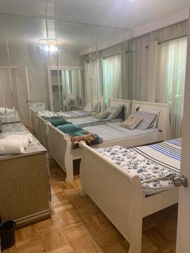 a room with four beds and a large mirror at Montreal Downtown Private Room in Montreal