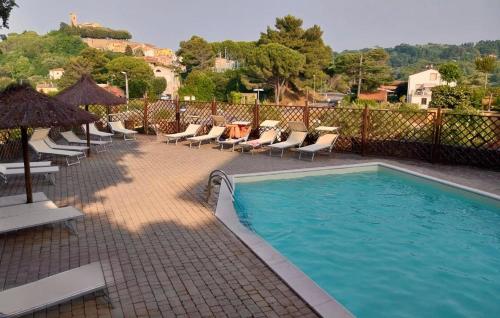 a swimming pool with chaise lounge chairs at Trilocale con piscina in Montescudaio