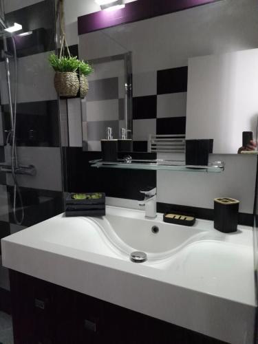 une salle de bain avec un lavabo blanc et un miroir dans l'établissement L étoile de mer, à Saint-Pair-sur-Mer