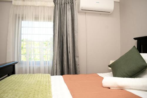 ハボローネにあるChillz Homeのベッドと窓のある寝室