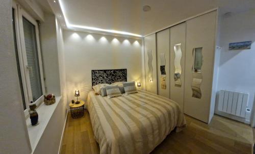 une chambre avec un grand lit avec des oreillers dessus dans l'établissement L étoile de mer, à Saint-Pair-sur-Mer