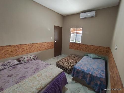 a bedroom with two beds and a window at Espaço Acácia in Petrolina