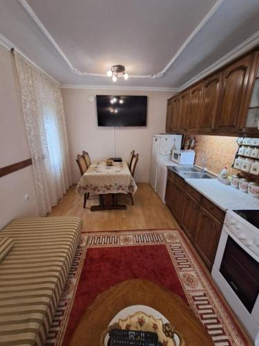 a kitchen with a table and a small kitchen with a table and a tableablish at Apartment White in Bijela