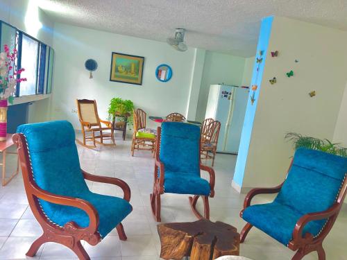 a living room with blue chairs and a table at El Podio, casa quinta vacacional Ricaurte in Ricaurte