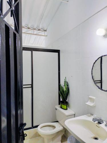 a white bathroom with a toilet and a sink at El Podio, casa quinta vacacional Ricaurte in Ricaurte