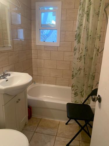 a bathroom with a tub and a sink and a toilet at Montreal Downtown Private Room in Montreal