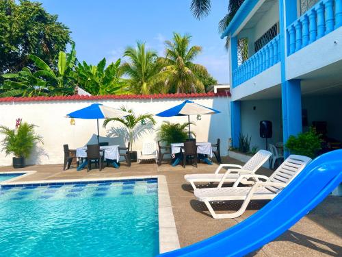 a pool with chairs and tables and umbrellas at El Podio, casa quinta vacacional Ricaurte in Ricaurte