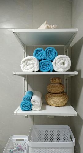 a closet with white towels and blue and white towels at Evan's place in Chorafakia