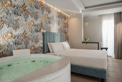 a hotel room with a bed and a tub at Hotel Grazia Riccione in Riccione