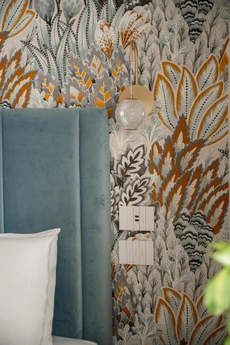 a bedroom with a wall with a floral wallpaper at Hotel Grazia Riccione in Riccione
