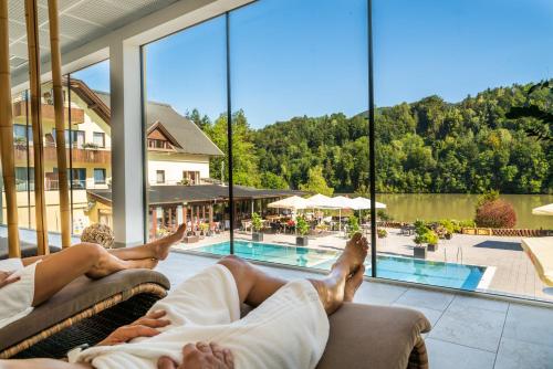 two people laying on a couch in front of a pool at Feriendorf Rosental by S4Y - Selbstversorger Appartements in Feistritz im Rosental