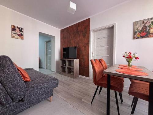 a living room with a table and a couch at Apartament A - Rynek 4, Pasym in Pasym