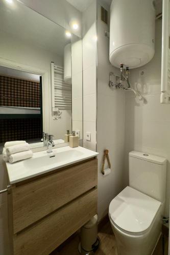 a bathroom with a toilet and a sink and a mirror at El Chozo in La Pinilla