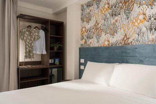 a bedroom with a white bed and a closet at Hotel Grazia Riccione in Riccione