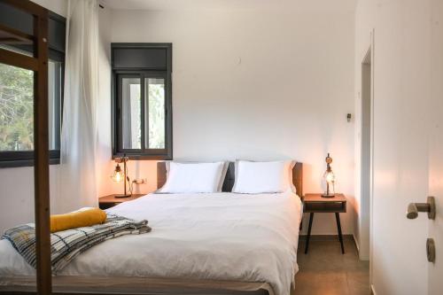 a bedroom with a bed with white sheets and a window at Aliyah - Country Garden Apartment in Matta‘