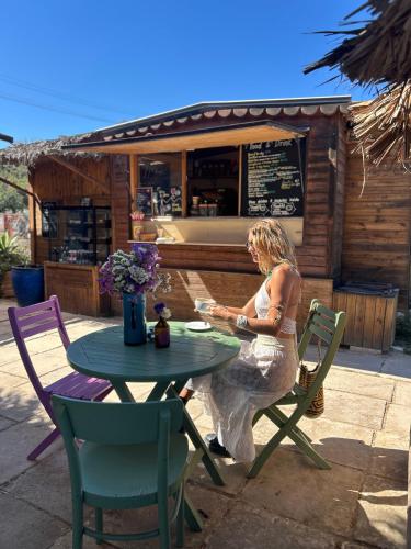 a woman sitting at a table in front of a restaurant at Ta Skorba Farmhouse Mgarr in Mġarr