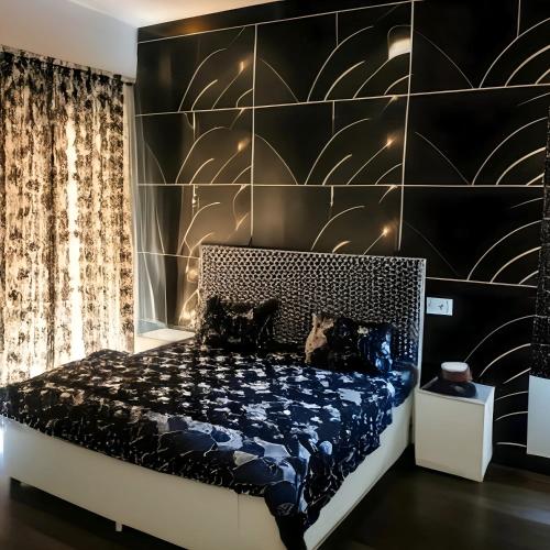a bedroom with a bed with a black wall at SAAR Palampur Villa 5 BHK With Dhauladhaar Mountains View in Pālampur