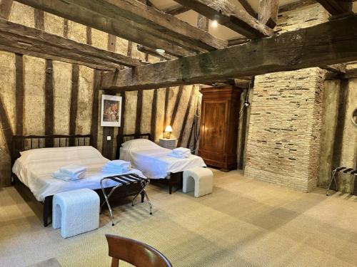 a room with two beds and tables in a building at Domaine du Cèdre Eternel in Saint-Colomb-de-Lauzun