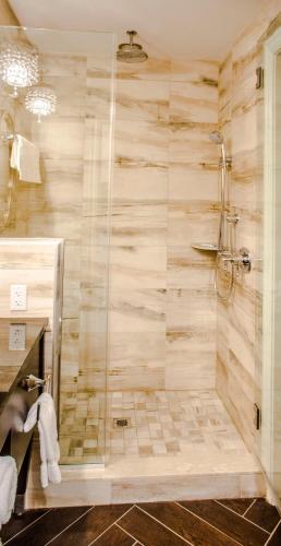 a bathroom with a shower with a glass door at The Delavan Hotel in Buffalo