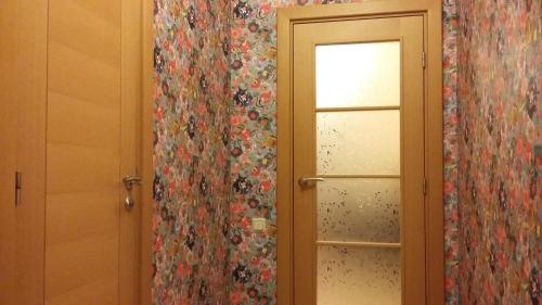 a bathroom with a door and a window with floral curtains at Harmony Life Two-room apartment in Riga in Rīga