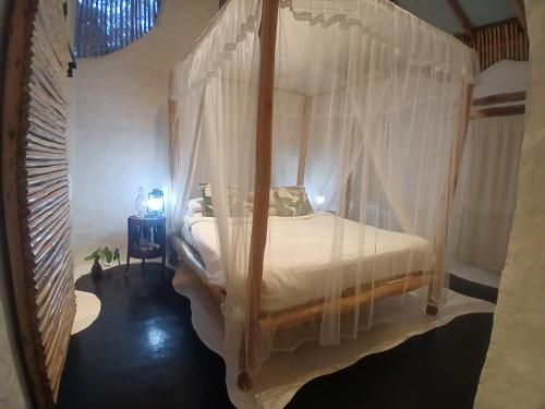 a bedroom with a canopy bed with white curtains at Ella Retreat Hotel Villa for Nature Lovers in Ella