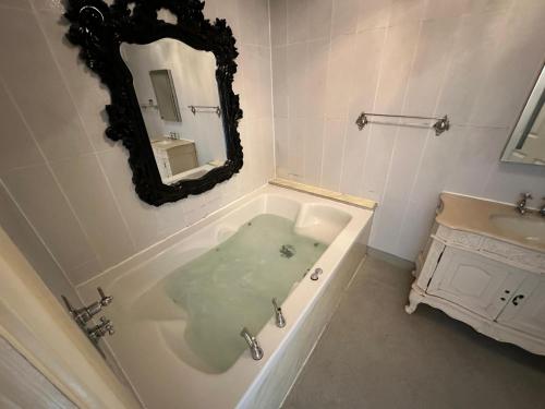 a bathroom with a bath tub with a mirror at White Star Line Hotel in Liverpool