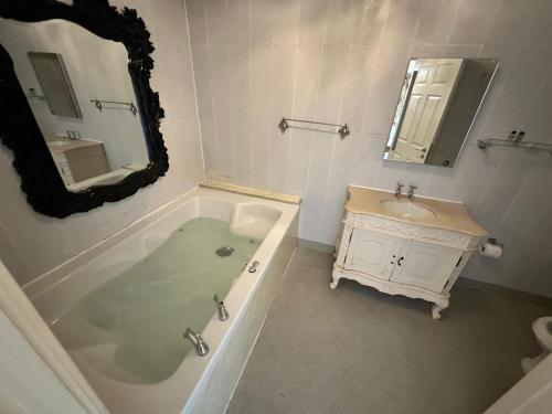 a bathroom with a tub and a sink and a mirror at White Star Line Hotel in Liverpool