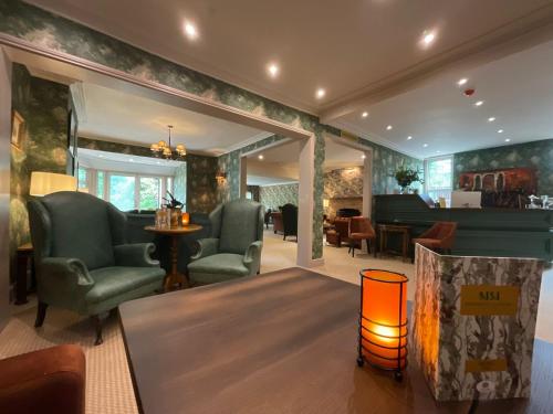a living room with two chairs and a table at Moorhill House Hotel in Burley