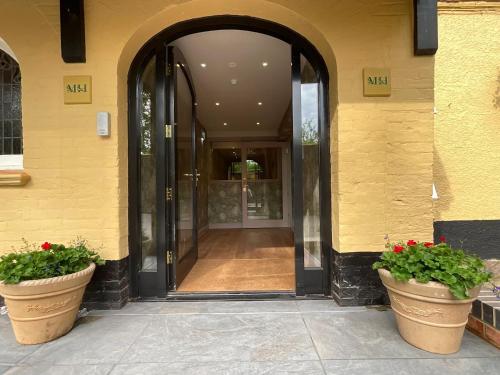 an entrance to a building with two large potted plants at Moorhill House Hotel in Burley