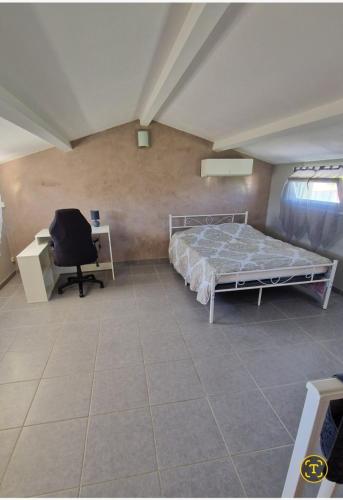 une chambre avec un lit, un bureau et une chaise dans l'établissement loft de la calade, à Frontignan