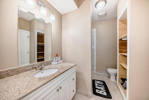 a bathroom with a sink and a toilet at Cozy bedroom in quiet community in Calgary