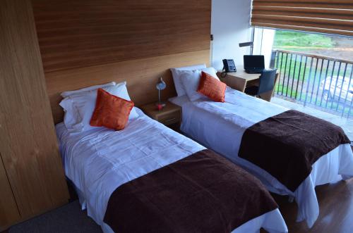 a hotel room with two beds and a balcony at Ruta Hotel Alto La Cruz in Los Ángeles