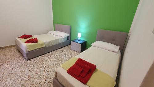 two beds in a room with green walls at Casa Nonna Rosa in Balestrate