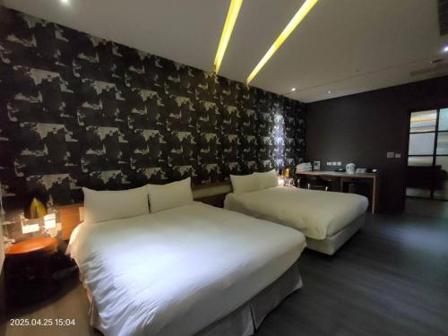 a hotel room with two beds and a black wall at 凝萃 水岸隱邸-NCH G11 Hotel in Taichung