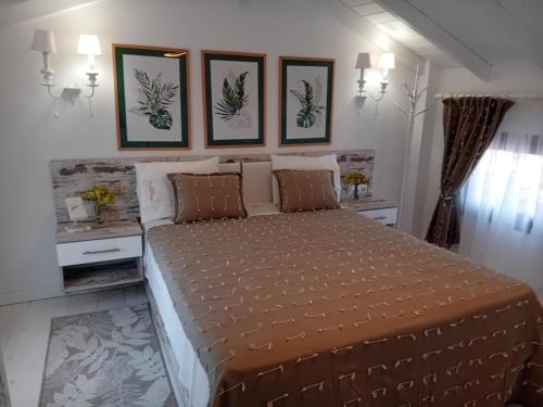 a bedroom with a large bed with three pictures on the wall at AGORA LUXURY LOFT in Ayios Nikolaos Sithonia