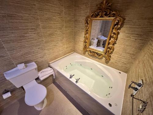 a bathroom with a tub and a toilet and a mirror at White Star Line Hotel in Liverpool