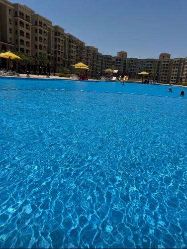 a large pool of blue water with buildings in the background at قريه اكوا فيو الساحل الشمالي العلمين in El Alamein