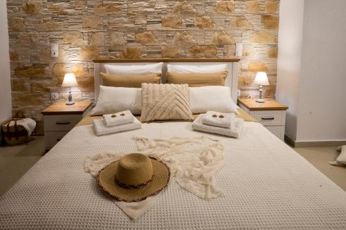 a bedroom with a large bed with a hat on it at Tsolias Stone House 2 in Palekastron