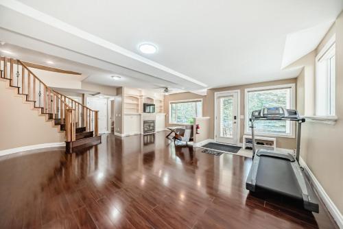an empty living room with a treadmill in it at Cozy bedroom in quiet community in Calgary
