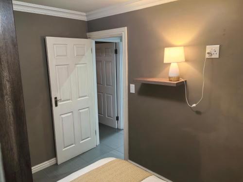 a room with a door and a lamp on a wall at The Close in Gqeberha