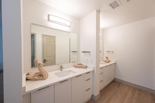 a bathroom with two sinks and a large mirror at Live Beautifully Uptown in Charlotte