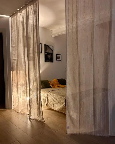 a bedroom with a bed and a window with curtains at Monolocale con giardino in Villa Opicina