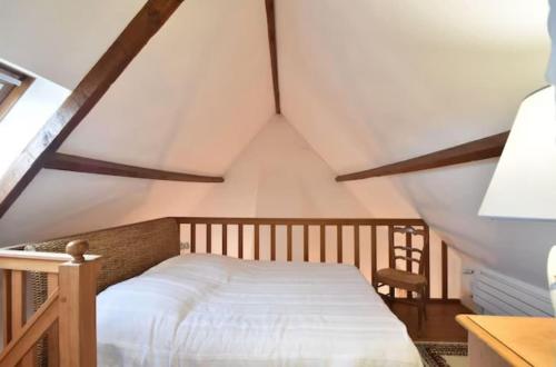 une chambre avec un lit dans un grenier dans l'établissement Gîte du Netz, à Appeville